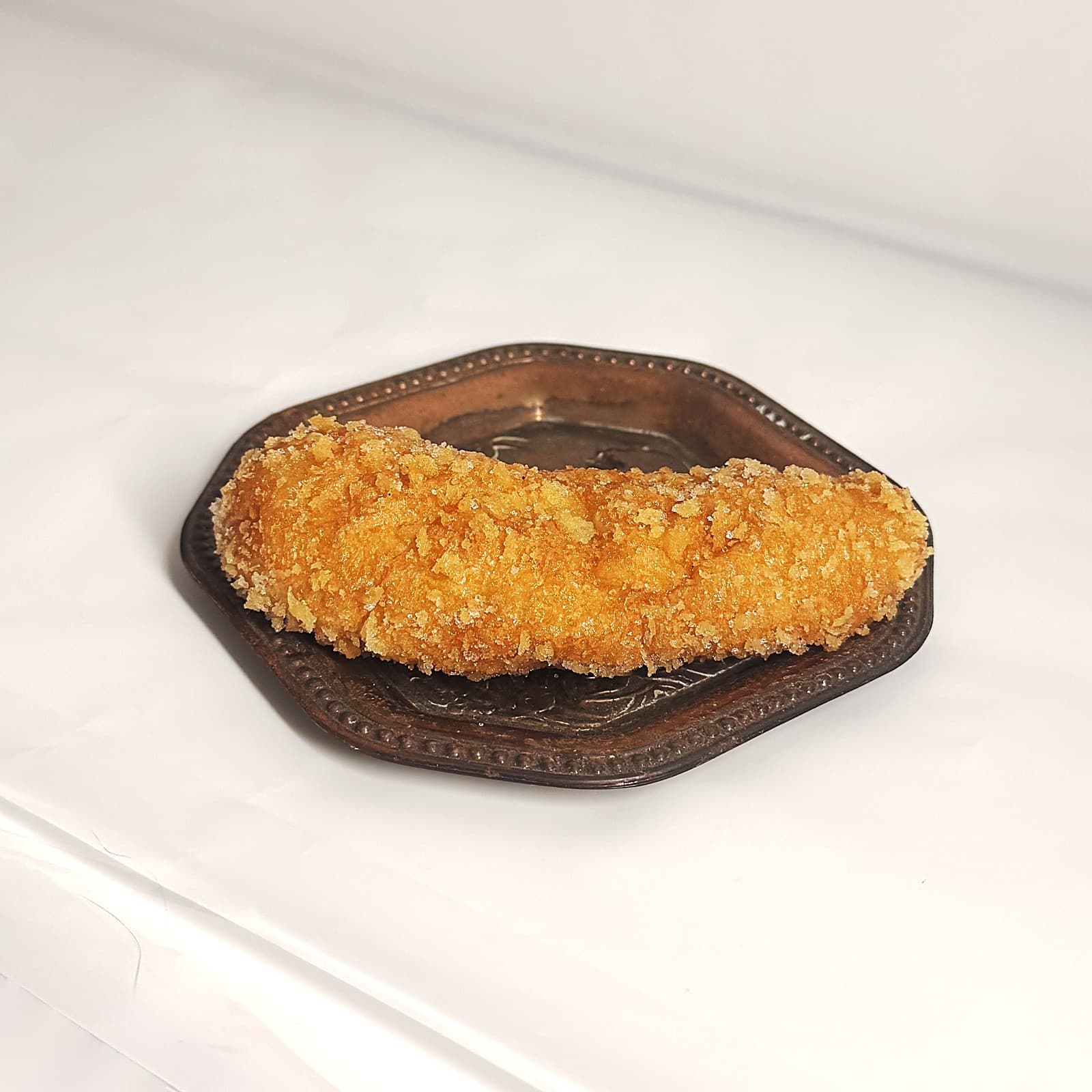 Freshly fried bicho rolled in sugar, on a bronze tray